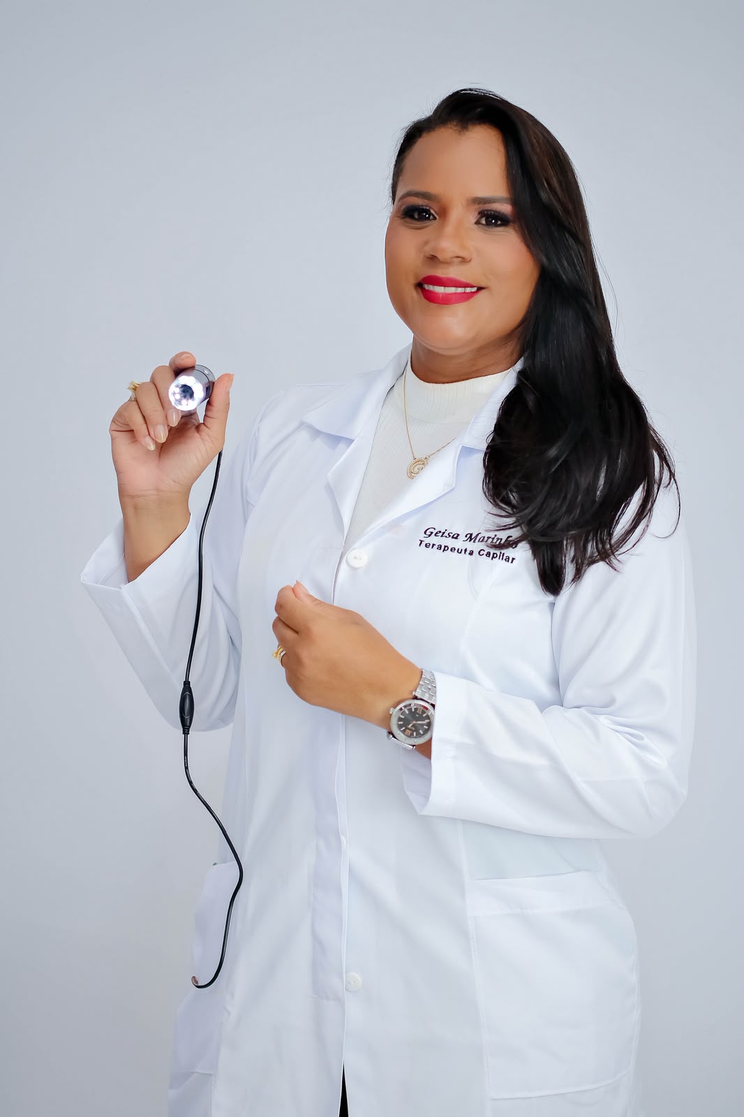Geisa Marinho de jaleco, com a microcâmera usada na tricoscopia
